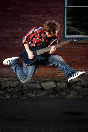 senior portrait jumping with guitar