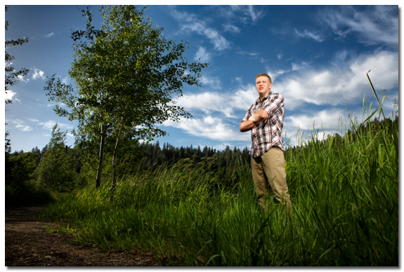 senior portrait with blue sky and clouds