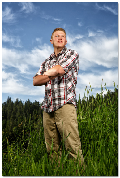 senior portrait with blue sky and clouds