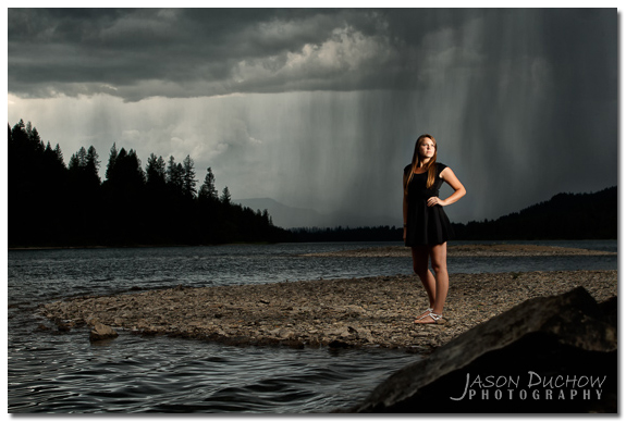 senior portrait with dramatic clouds and rain in the distance
